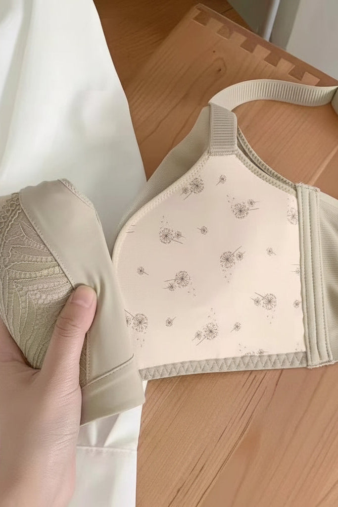 A beige embroidered wireless contour bra on a wooden surface, showing the floral-pattern padded inner cup detail.