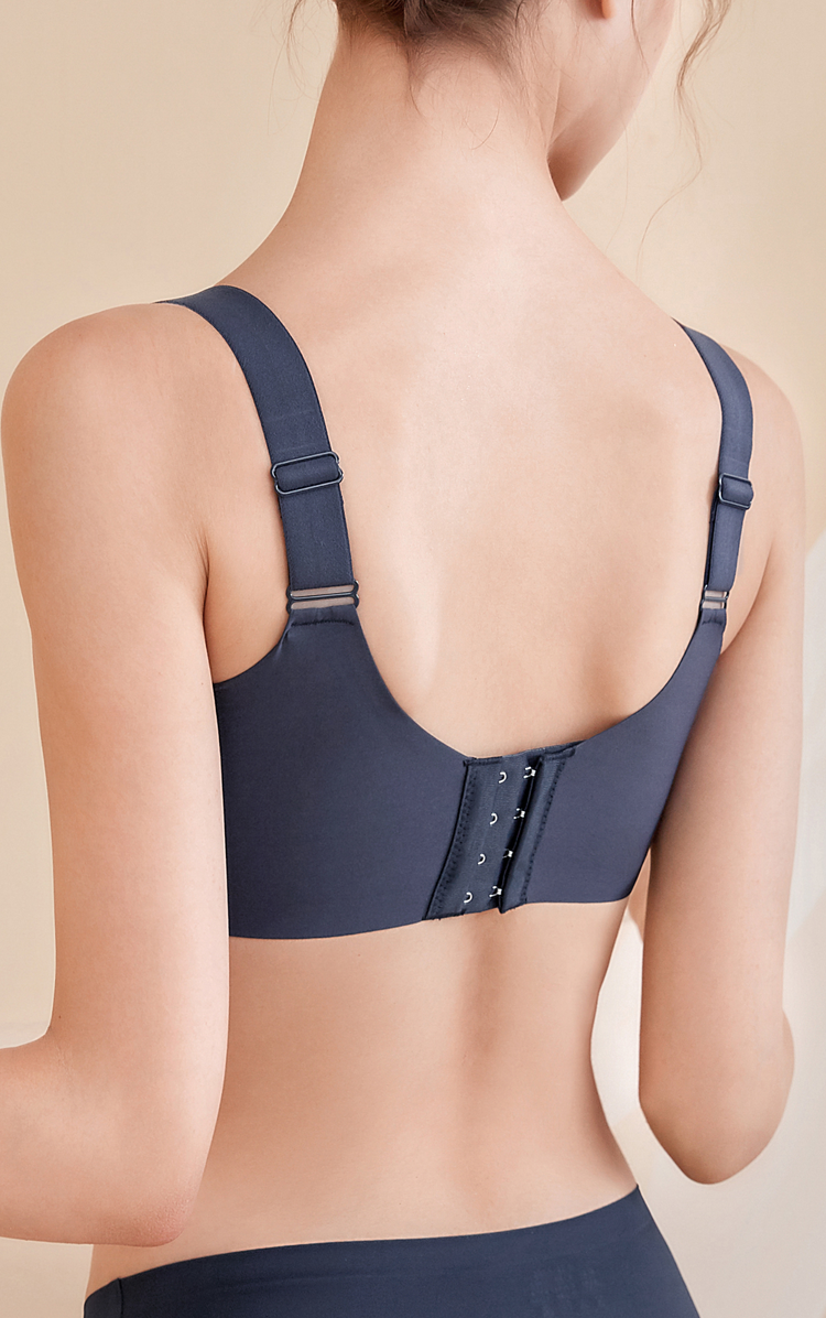 Back view of a woman wearing a navy blue wireless bra with wide adjustable straps and a secure three-hook closure, designed for a smooth and comfortable fit with back support.