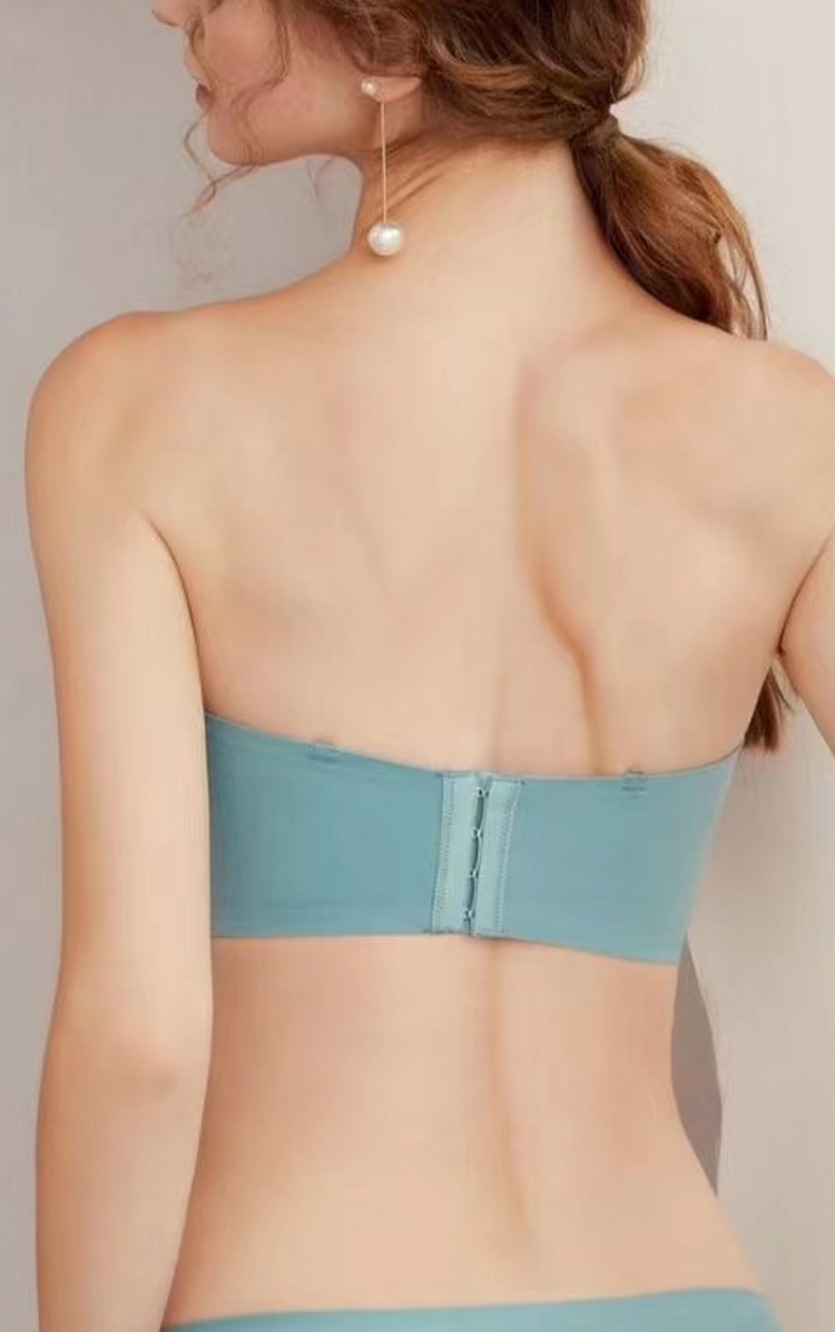 Back view of a woman wearing a blue strapless bra, highlighting the wide sidebands and seamless design.