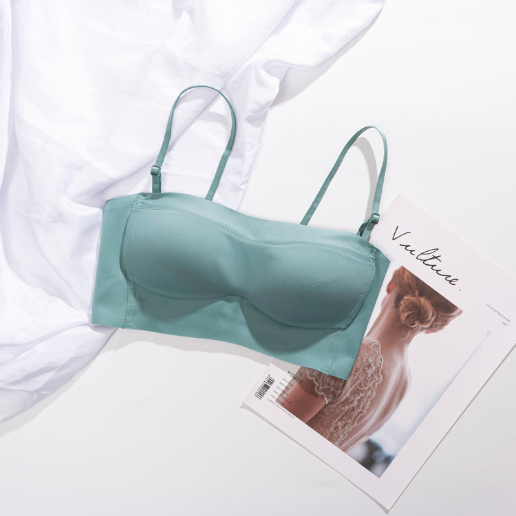 Front view of a blue strapless bra displayed on a flat surface, with removable straps beside it.