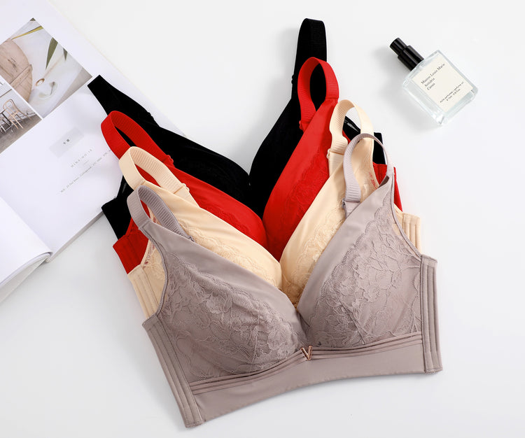 A selection of wireless lace push-up bras in various colors (pink, beige, red, and black) displayed on a flat surface, showcasing their elegant lace details and seamless design.
