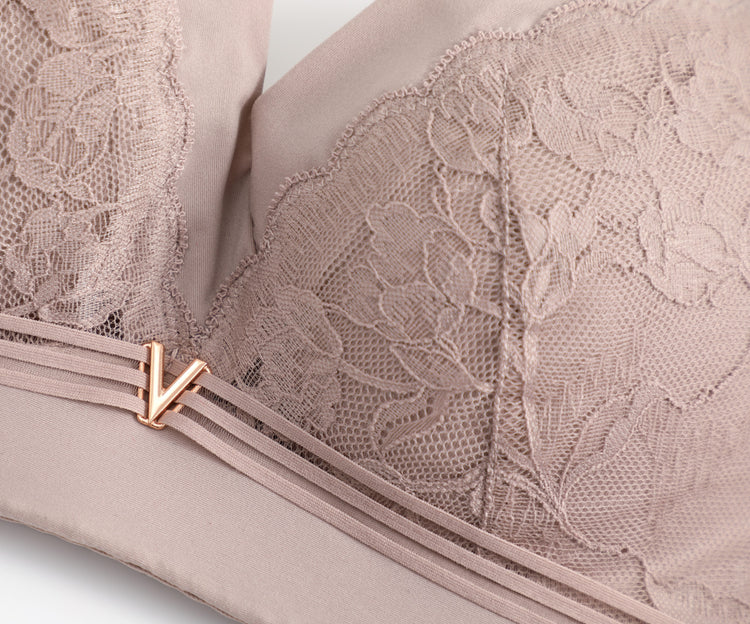 Close-up of the delicate lace embroidery on a pink wireless lace push-up bra, highlighting its intricate floral detailing and seamless craftsmanship.